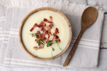 Delicious potato soup with bacon and microgreens in bowl served on table, flat lay