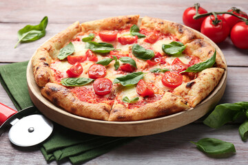 Delicious Margherita pizza and cutter on wooden table, closeup