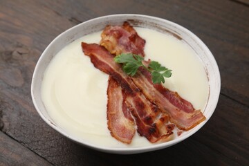 Delicious potato soup with bacon and parsley on wooden table
