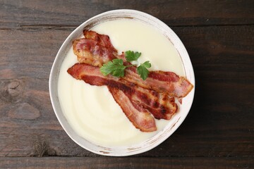 Delicious potato soup with bacon and parsley on wooden table, top view