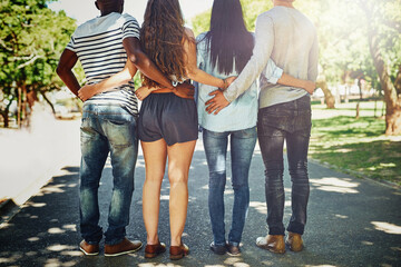 People, park and group of friends with hug in nature for support, solidarity and bonding on vacation. Students, hands and back with embrace for love, peace and friendship on holiday in Manhattan