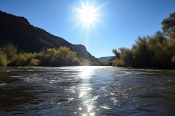 Captivating view of a serene river with glistening water amidst towering cliffs under a bright sun