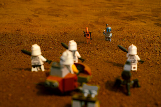 Depok, Indonesia - May 17, 2024: Lego toys photography, jango fett and battle droid facing phase 1 clone troopers during the battle of geonosis recreation, in the middle of  sandstorm