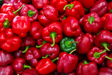 Many of red bell pepper on the counter in the grocery store. Close-up image