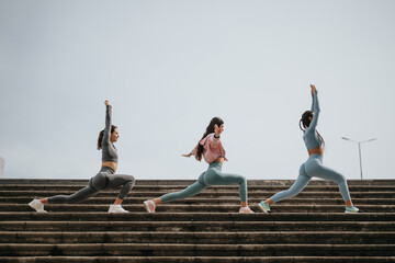 Outdoor fitness session capturing three athletic women doing lunges on stairs, highlighting health...
