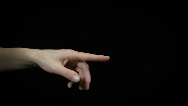 Lady finger point on the black background. A lady with pointing finger on black background. A concept of showing something indoor.