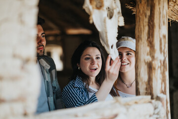 Three young tourists engaged in discovering old, rustic ruins. Friends share a bond and curiosity while exploring historical artifacts during a sunny holiday.