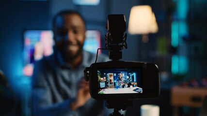 Close up on professional camera capturing content creator filming review of V mount battery unpacking to audience. Recording device filming influencer showing charging device to viewership