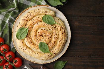 Delicious puff pastry with spinach on wooden table, flat lay