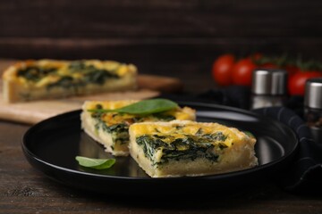 Pieces of delicious pie with spinach on wooden table, closeup