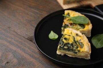 Pieces of delicious pie with spinach on wooden table, closeup. Space for text
