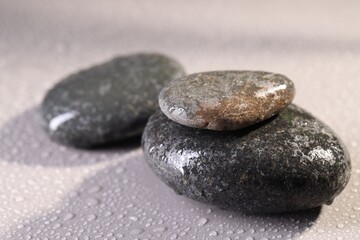 Wet spa stones on grey background, closeup