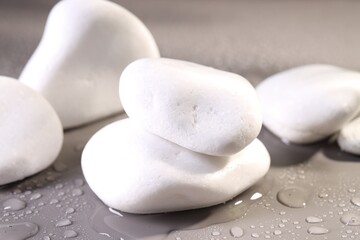 White spa stones with water drops on grey background