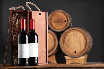 Wooden boxes and wine bottles on table against dark background. Space for text