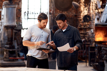 Men, teamwork and metal workshop with tablet for manufacturing inventory, small business or factory. Male people, coworker and steel production as blacksmith career or digital app, startup or welder