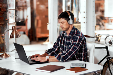 Fototapeta premium Business, office and man with laptop, headphones and typing with deadline, streaming music and connection. Person, employee and consultant with pc, headset and relax with schedule, network or project