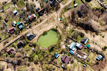Aerial view of village buildings and a green pond. Kaluga region, Russia