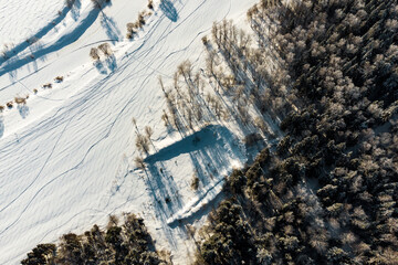 View from above of snow-covered nature, an abandoned shooting range on the edge of the forest