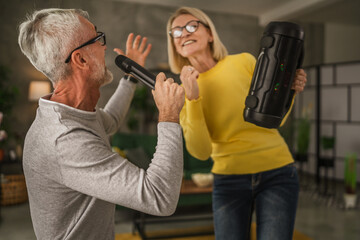 Mature man hold microphone and sign while mature wife hold loudspeaker