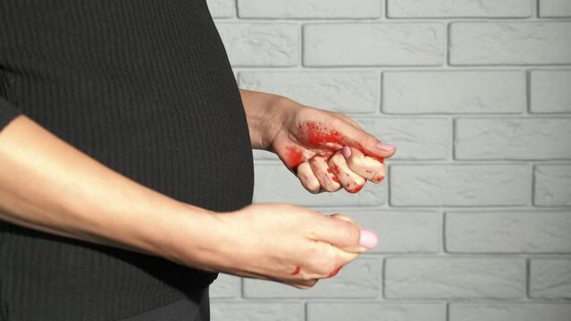 Miscarriage trouble. A view of female hands in blood during miscarriage problems in life.