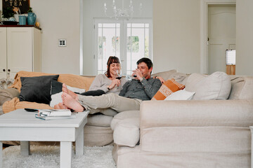 Couple, happy or relax with wine glass in living room for romance, love and bonding together on...