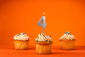 Candle number 4 - Celebration with birthday cupcake on orange background