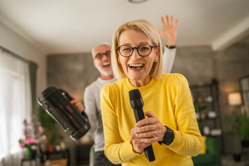 Mature wife hold microphone and sign while husband hold loudspeaker