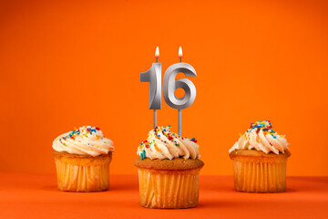 Candle number 16 - Celebration with birthday cupcake on orange background