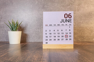 June 21 calendar date text on wooden blocks with blurred nature background.