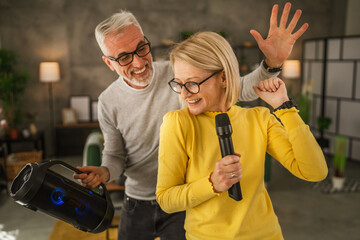 Mature wife hold microphone and sign while husband hold loudspeaker