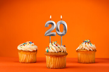 Candle number 20 - Celebration with birthday cupcake on orange background