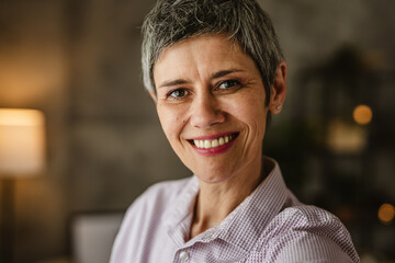 Self portrait of mature woman stand and smile at home