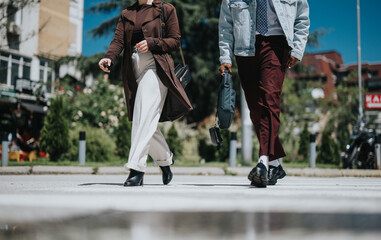 Two fashion-forward young professionals stride across a city street, showcasing modern urban style...