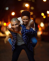 Happy, couple and piggyback in city at night on adventure or excited to travel on journey together....