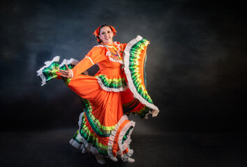 Mexican woman with escaramusa costume jalisco mexico orange color A woman in a colorful dress is dancing