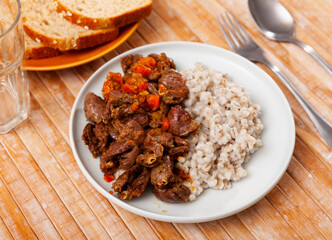 National Russian dish is pearl porridge with stewed chicken hearts. Served with bread..