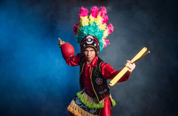Matlachines Dancer from Coahuila Mexico A man in a red costume with a feather headdress and a drum