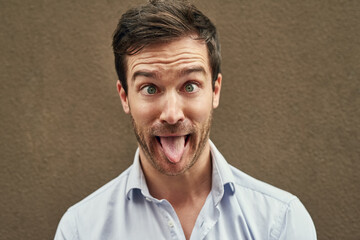 Man, tongue and funny face on isolated background in silly, goofy or comedy on mockup or wall...