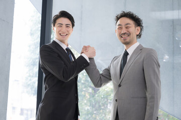 力強く握手をするカメラ目線のビジネスマン　成功や協業、協力のビジネスイメージ