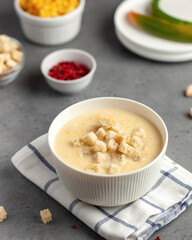 Creamy corn soup topped with croutons, offering a warm and comforting meal