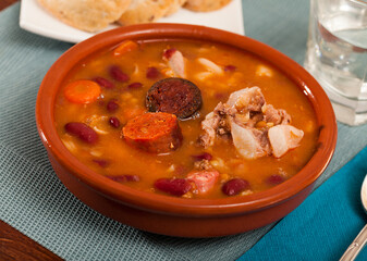 Fabada asturiana - beans stewed with chorizo and bacon served on clay pot