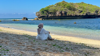 Indonesian young woman in hijab enjoying holiday on the beach