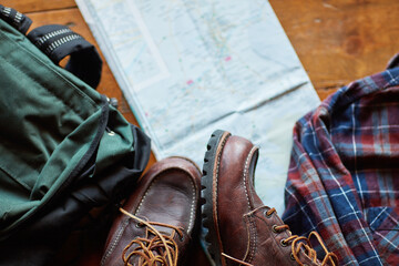 Hiking, boots and backpack for journey with map for adventure, wellness and fitness or wellbeing,...