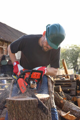 Man sawing wooden log on sunny day