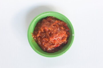 Portrait of tomato chili sauce in a green bowl isolated on a white background.