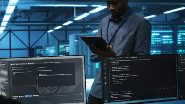 Technician in server hub using tablet to find hardware misconfigurations affecting rackmounts performance. Man checking data center infrastructure devices bottlenecks leading to errors