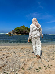 Indonesian young woman in hijab enjoying holiday on the beach