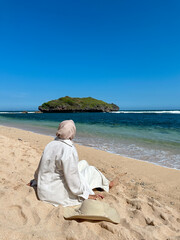 Indonesian young woman in hijab enjoying holiday on the beach