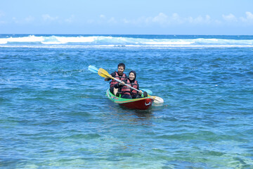 Fototapeta premium indonesian Young couple canoeing enjoying holiday on the beach