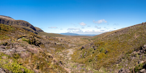 Naklejka premium Dramatic landscape of rugged volcanic terrain with Mount Ngauruhoe, Mount Doom, iconic hiking spot in Tongariro National Park, New Zealand